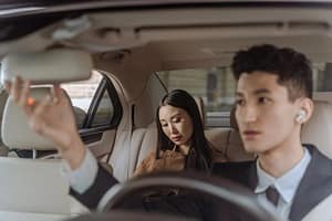chauffer driving a woman passenger